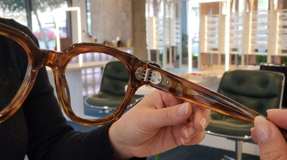 A detailed view of artisan craftsmanship in a pair of luxury glasses at a San Diego optometry practice.